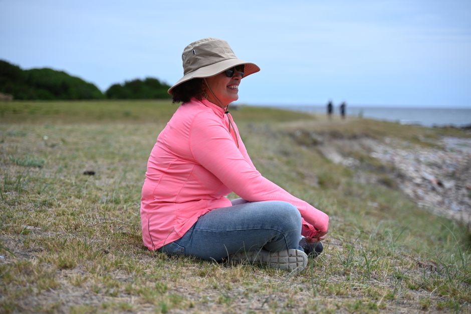 A woman in casual attire enjoys a peaceful day at the beach.
