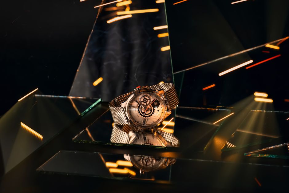 Elegant silver wristwatch on a reflective surface with dynamic lighting effects.