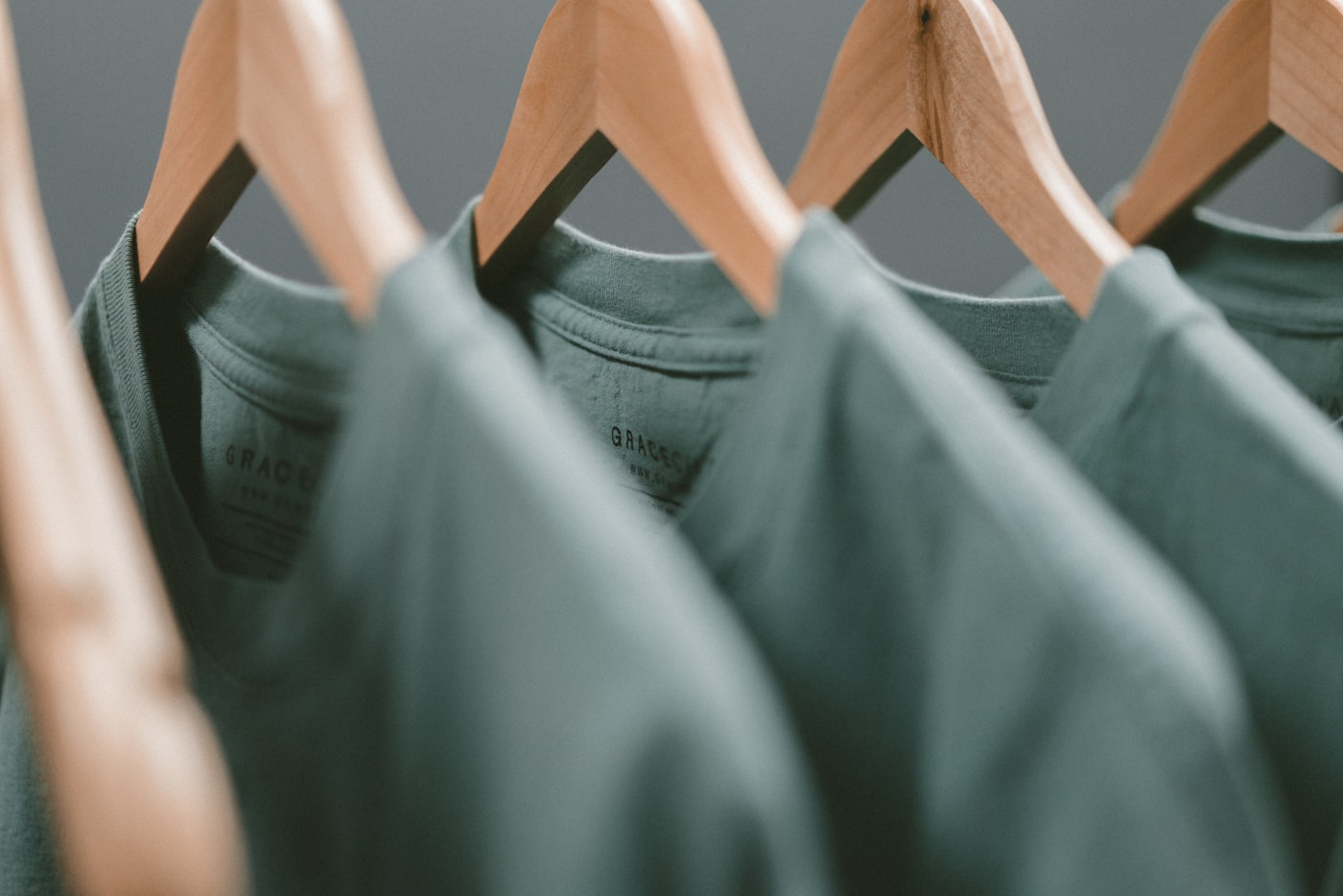Neutral T shirts arranged neatly on wooden hangers