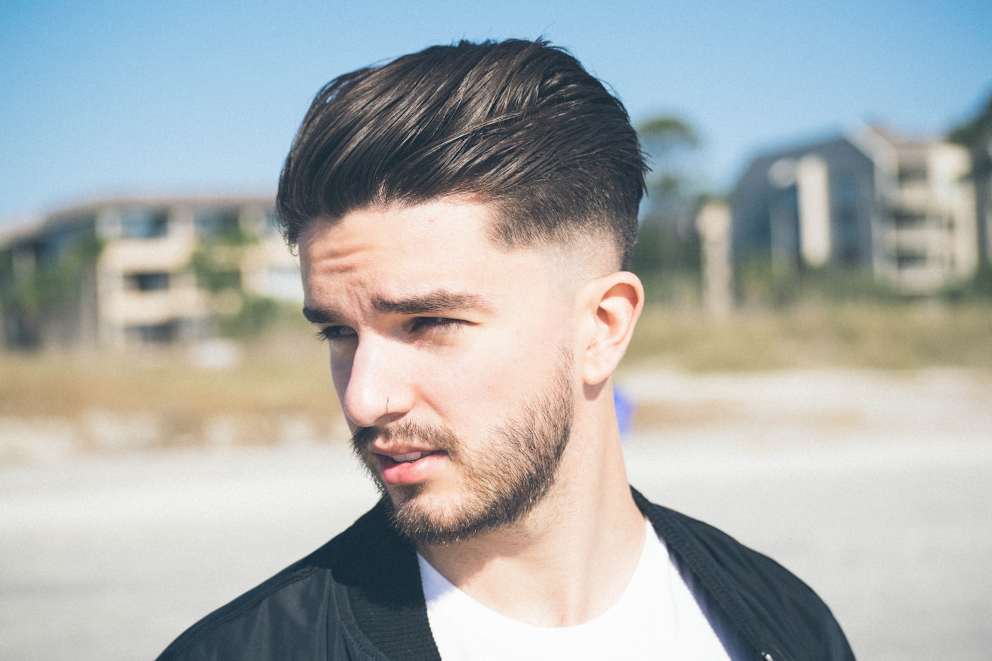 Man with a clean haircut and casual jacket outdoors