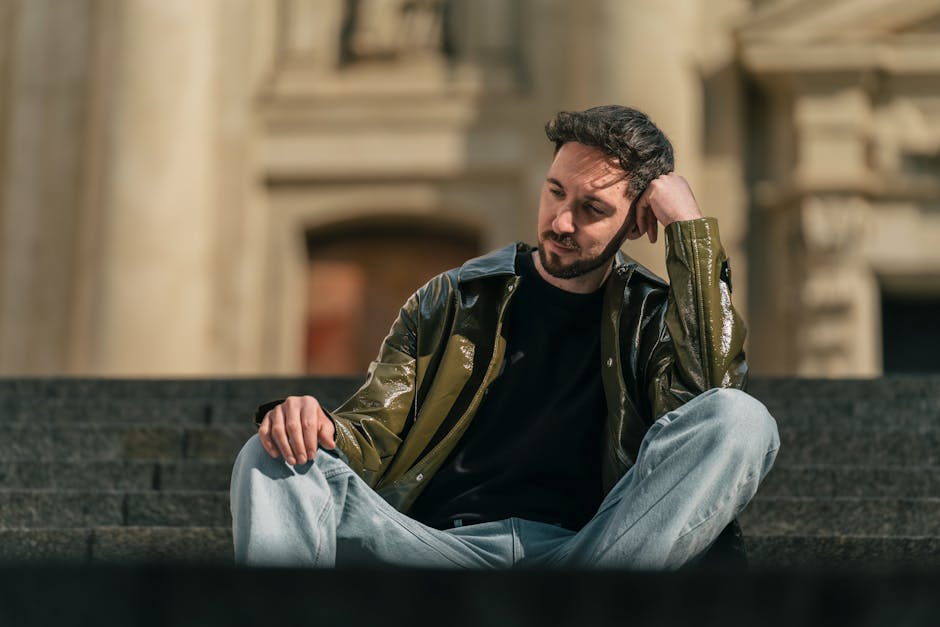 Casual stylish man seated on outdoor steps, embracing a relaxed urban vibe.