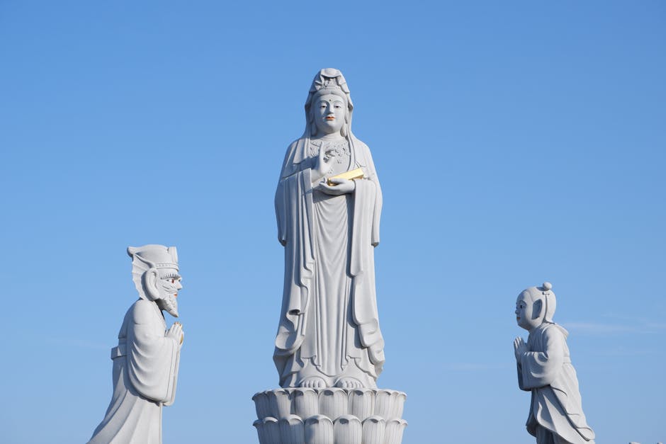Elegant statues of Kwan Im under a clear blue sky in South Korea.