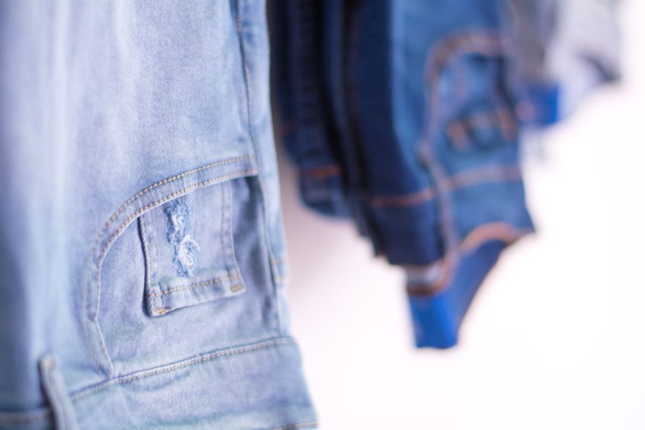 A detailed view of blue denim jeans hanging in a retail store showcasing fashion style.